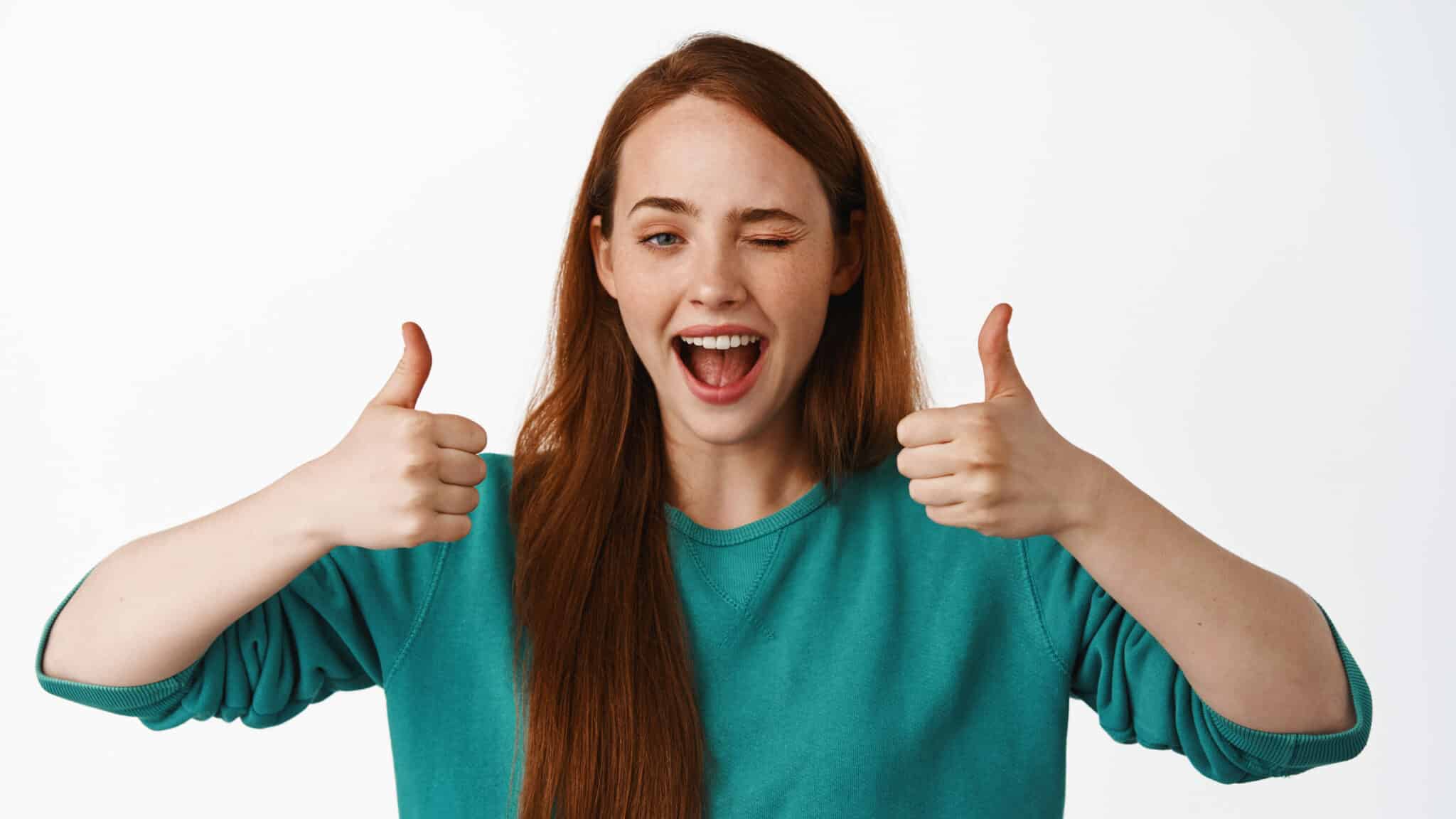 well done smiling redhead girl winking show thumbs up like approve praise nice job great work gesture hinting something good recommend service edited scaled - Emir Al Kafadji